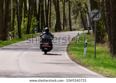 A motorcycle at the end of a road section with speed restriction