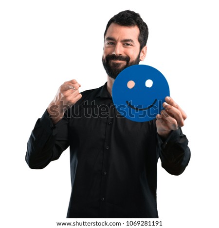 Handsome man with beard holding a happy face icon on white background