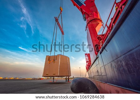 heavy lift packages cargo shipment lifting by the jumbo ship crane for delivery and transport to destination by sea and lands logistics services Royalty-Free Stock Photo #1069284638