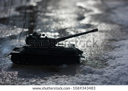 military simulation. The loaded tank is ready for attack. a toy tank at night on the background of ice.