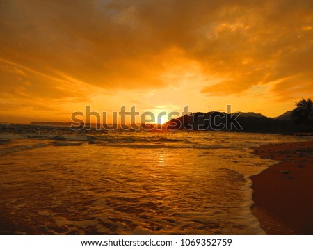 beautiful sunrise on kauai north shore, sun reflecting off volcanic clouds