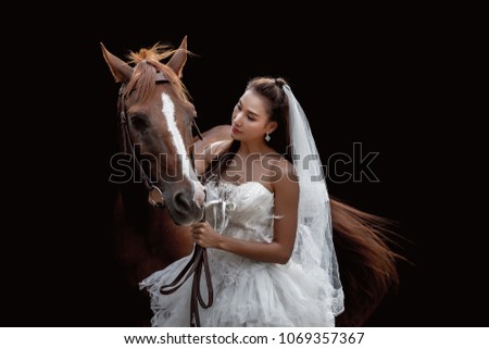 Beautiful bride with horse on black background