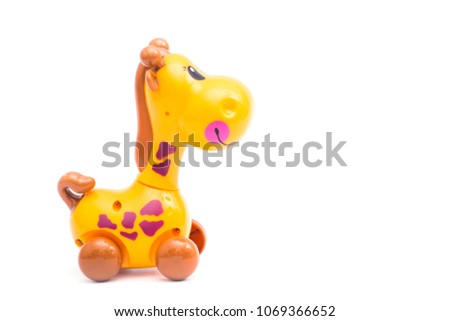 Mechanical giraffe toy. Clockwork plastic toy isolated on left hand with white background.