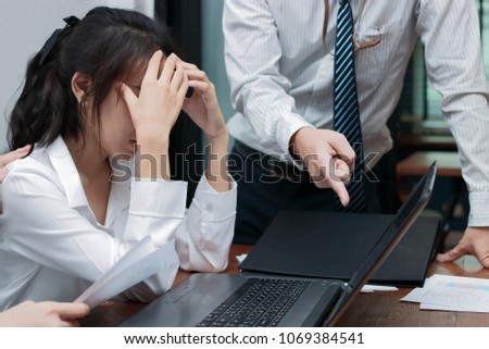 Angry boss blaming young Asian woman with hands on face in office. Royalty-Free Stock Photo #1069384541
