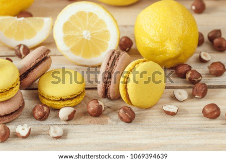 Yellow and brown french macarons with lemon and hazelnuts, soft focus background