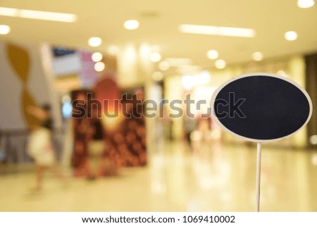 black sign, on blurred photo shopping mall center and people background