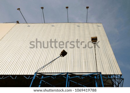 Big empty advertisement billboard on blue metal structure on cloudy blue sky day