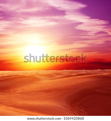 Sunset in desert. Beautiful landscape with sand dunes, cloudy sky and sun Royalty-Free Stock Photo #1069420868
