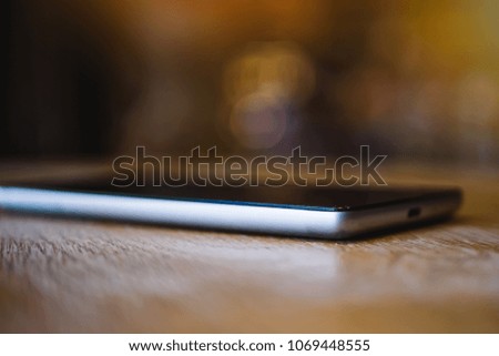 A smartphone rests on a table in a cafe