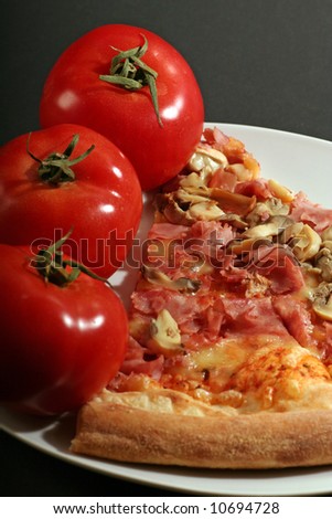 Pizza with tomatoes on a black background.