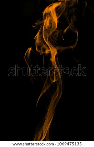 Smoke the orange incense on a black background. darkness concept