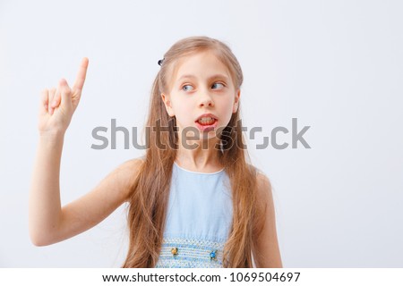 Little girl raising finger in funny attention gesture