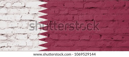 Texture of a flag of Qatar on a pink brick wall.