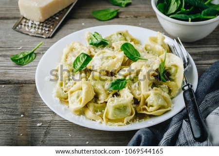 Italian ravioli pasta with spinach and ricotta on wooden rustic background Royalty-Free Stock Photo #1069544165