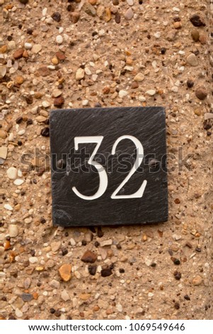 House number 32 sign on wall