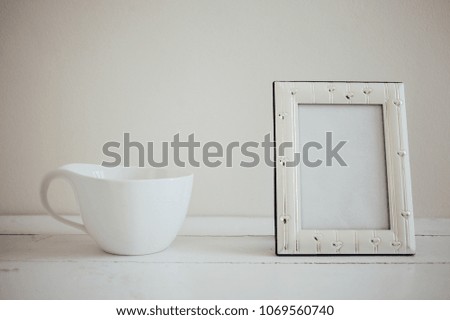 Photo frame and coffee cup on table cloth on wooden table - vintage effect style picture