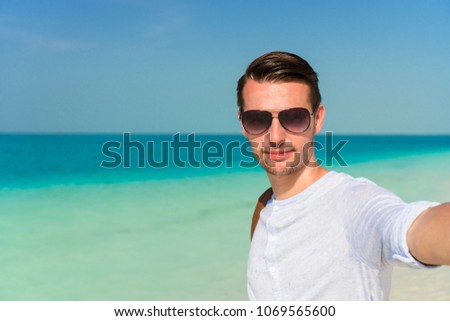 Young man taking selfie on tropical beach