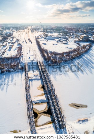Railway bridge over small frozen river Lielupe in Jelgava, Latvia. Captured from above with a drone.