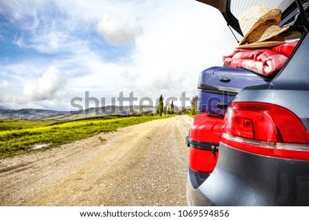 Summer trip in Tuscany. Car with open trunk on road and free space for your decoration. 
