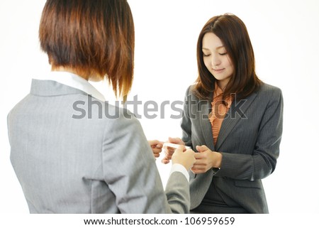 Two female office workers who change a business card each other