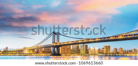 Amazing sunset view of Manhattan Bridge with East River reflections - New York City.