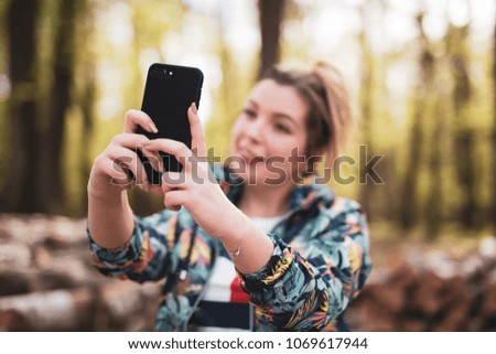 Blonde takes a selfie while walking in the woods