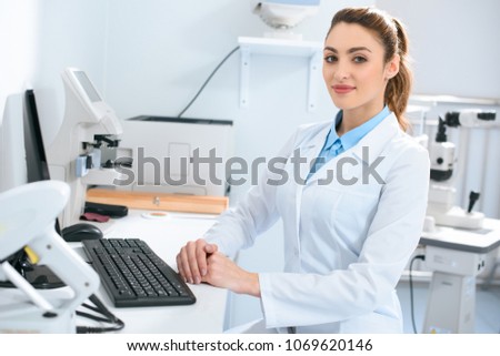 beautiful female optician working with computer in clinic Royalty-Free Stock Photo #1069620146