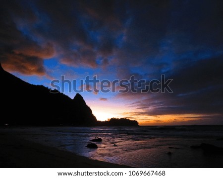 beautiful sunset on a beach on kauai island with passing clouds 
