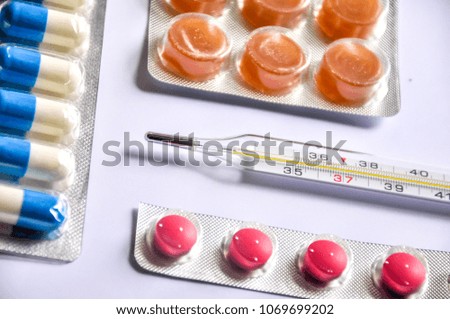 Thermometer and colorful drugs/pills. Concept.