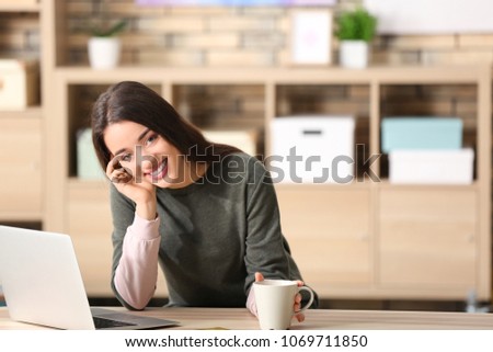 Young woman shopping online with laptop at table