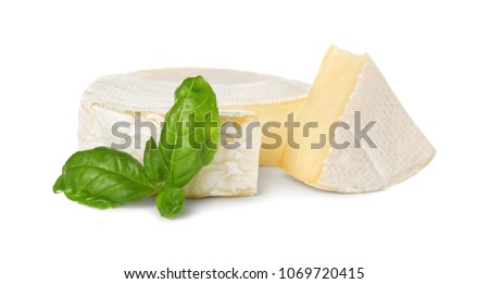 Delicious brie cheese with basil on white background Royalty-Free Stock Photo #1069720415