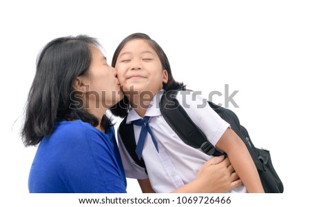 Mother kiss her daughter in uniform student before go to school isolated on white background, love and care concept