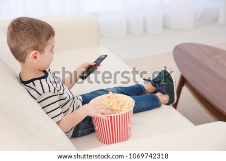 Little boy watching TV on sofa at home