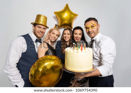 celebration and holidays concept - happy friends with big cake at birthday party
