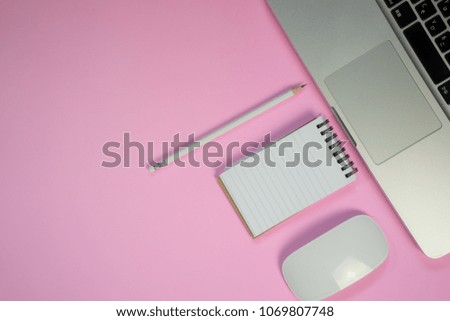 Flat lay style picture of workspace with office supplies on pink pastel coloured background. top view with copy space.