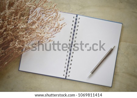 Top view of empty notebook and pencil with dry flowers ,soft photo vintage background concept.