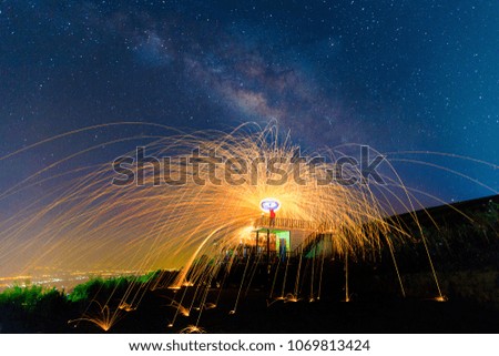 Milky Way at night, landscape from top of mountain with the man who turn fireworks in his hand on the roof and have bright milky way background.