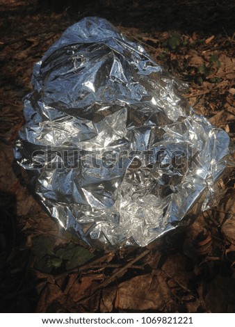 Abstract glare of light.
Crumpled shiny texture of silver foil for design.
Decorative reflective picture.
Creative Wallpaper or web banner of the wallpaper. 
Space aliens, glare of light on metal.