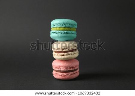 Stack of delicious macarons on dark background