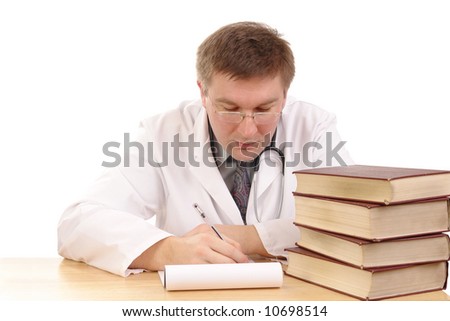 Young male doctor studying medical books and taking notes - shot over white background