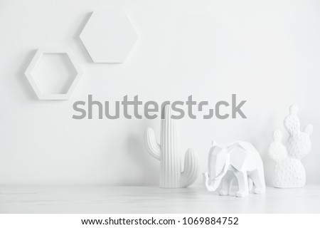 Creative desk with copy space , cacti, elephant. White concept of wall with hexagone shapes.