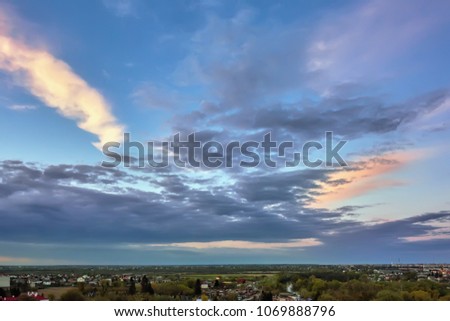 Sky with clouds over evening city at sunset.