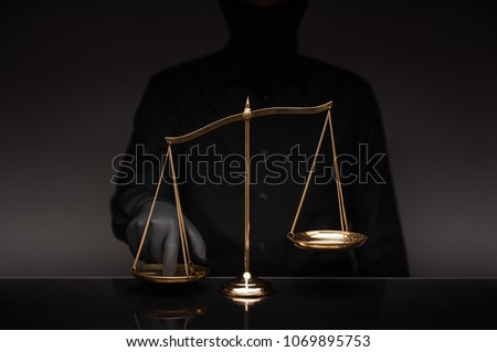 Someone wearing black shirt pressing the imbalance scale on black glass desktop and black background, cheating  in a lawyer's office, Concept of injustice, espionage, partiality, law.