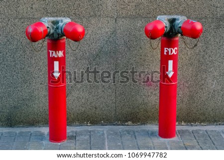 A red pipe of water valve tank and FDC (Fire Department Connection) at the outside of building.