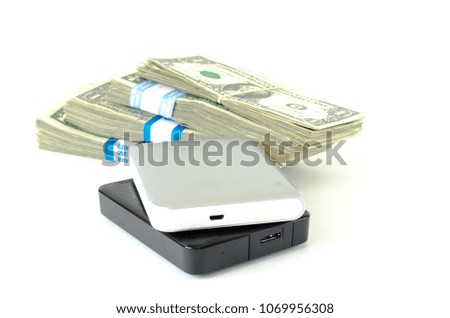 Information is valuable concept, data trading. Close-up portable external hard drives on stack of dollar bundles isolated on white. Clipping path with copy space background