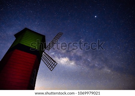 Landscape of milky way galaxy with wind turbine, Night sky with stars and silhouette of wind turbine and tree