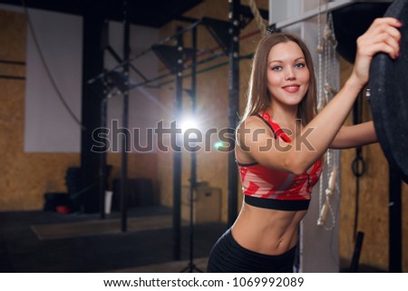 Photo of smiling sportswoman with barbell