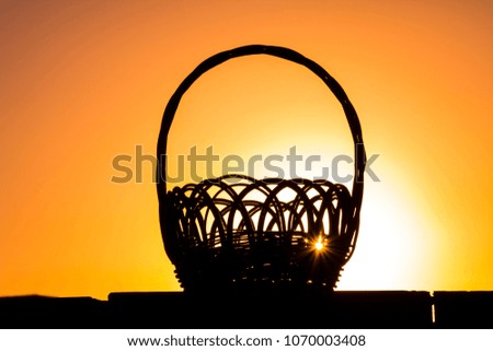 Flower basket silhouette in sunrise background, beautiful orange and yellow sky in golden hour.