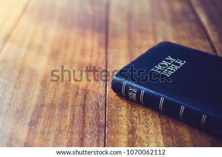 holy bible on wooden table background with soft morning sun light Royalty-Free Stock Photo #1070062112