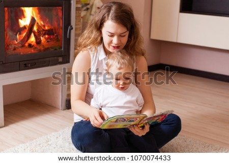 mother is reading for her son near fireplace